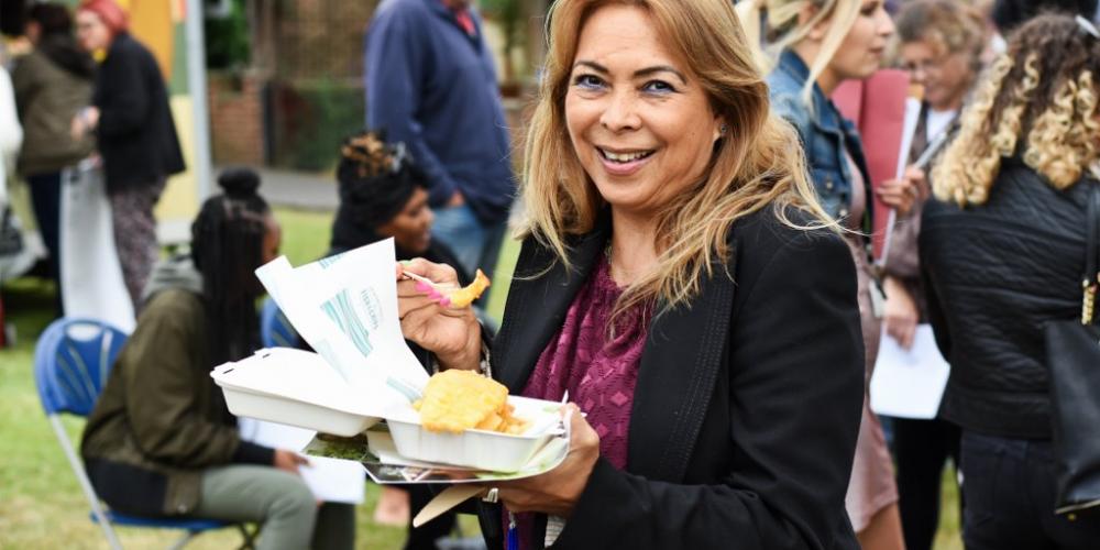 woman smiling holding fish and chips 
