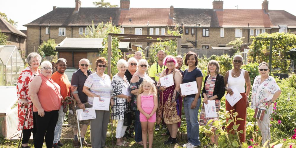 Phoenix in bloom gardeners at their prize giving, looking happy with certificates 
